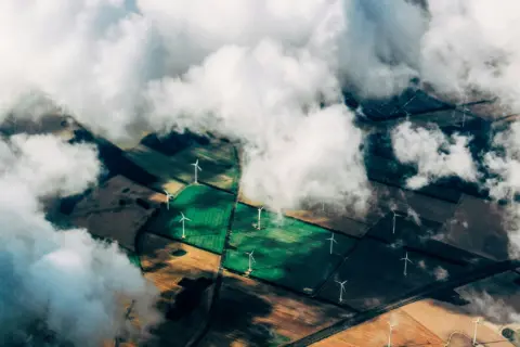 Felder von oben mit Wolken und Windrädern