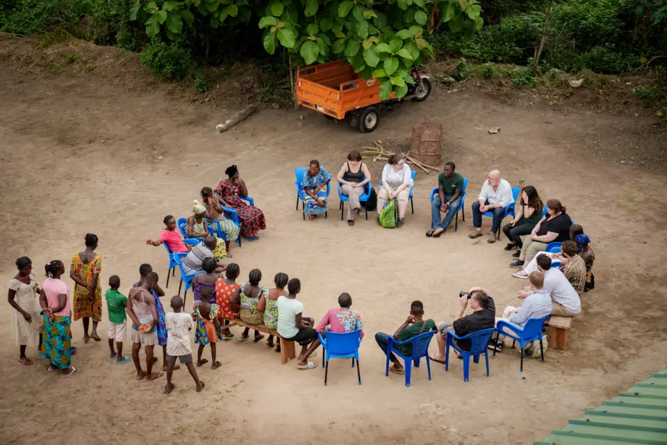 Blick aus der Vogelperspektive auf einen Stuhlkreis im Projektdorf in Togo: Das natureOffice-Team im direkten Austausch mit der lokalen Bevölkerung zur Planung von Klimaschutzmaßnahmen.