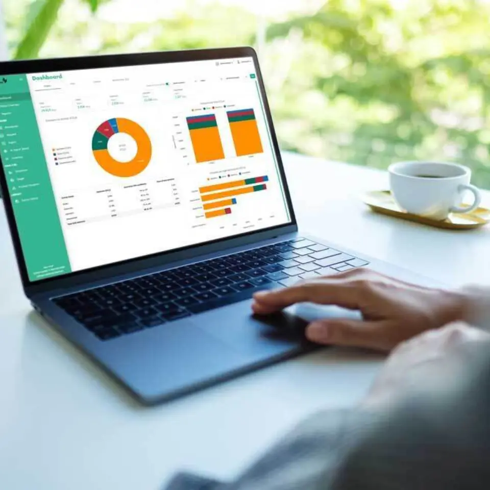 Person arbeitet am Laptop mit farbigen Diagrammen auf dem Bildschirm.