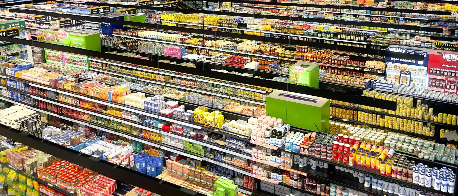 Top-down view of thousands of supermarket products, symbolizing 45,000 supplier requests and the shift of carbon footprints (PCF) into core purchasing decisions.